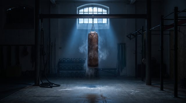 Art-direction sample: a gym heavy bag lit by a single dawn beam at 5 AM